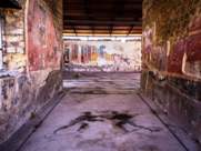 House in Pompeii ruins with mosaic of athletes in entrance corridor
